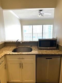 kitchen with light stone countertops, appliances with stainless steel finishes, and a sink