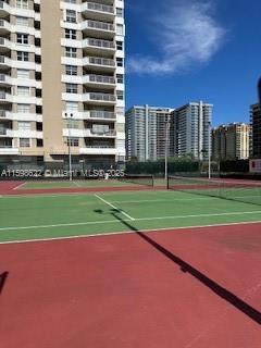 view of tennis court featuring community basketball court and a city view