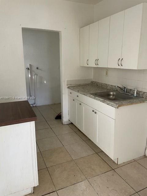 kitchen featuring sink, white cabinets, and light tile patterned floors