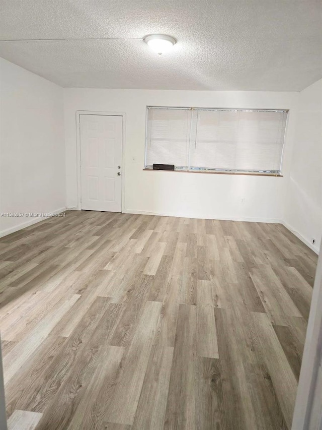 interior space featuring light hardwood / wood-style floors and a textured ceiling