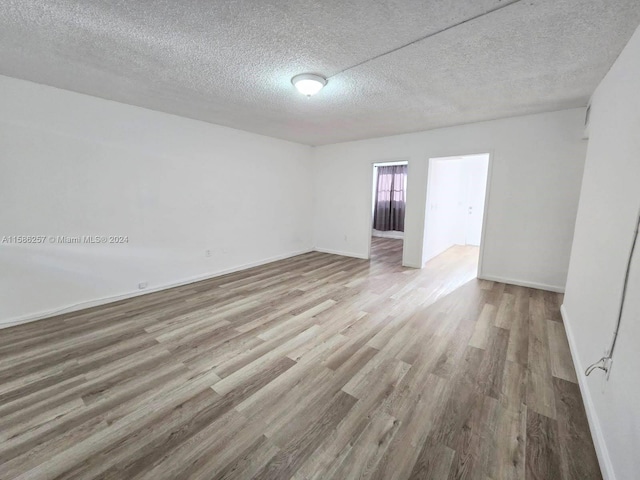 spare room with wood-type flooring and a textured ceiling