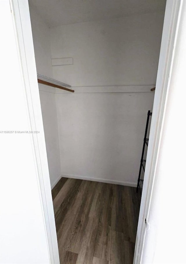 walk in closet with dark hardwood / wood-style flooring