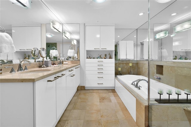 bathroom with a wall unit AC, vanity, and a relaxing tiled tub