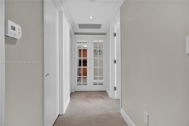 hall with french doors and light tile patterned floors