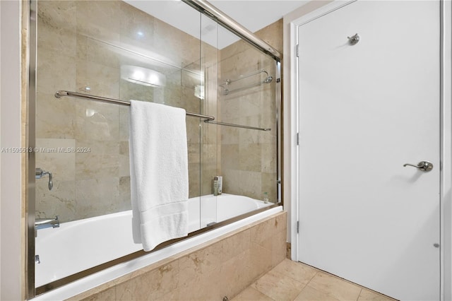 bathroom with shower / bath combination with glass door and tile patterned flooring