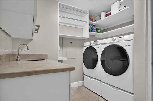 laundry room featuring washing machine and clothes dryer, light tile patterned floors, and sink