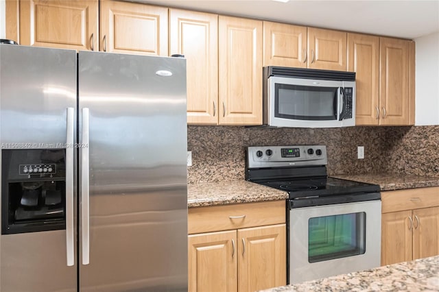 kitchen with appliances with stainless steel finishes, light stone countertops, tasteful backsplash, and light brown cabinetry