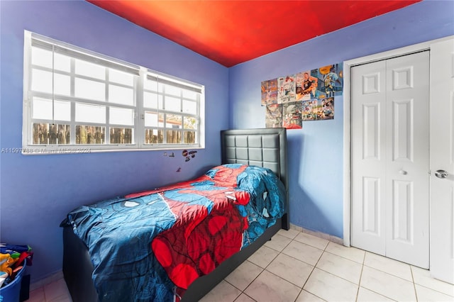 bedroom with tile floors and a closet