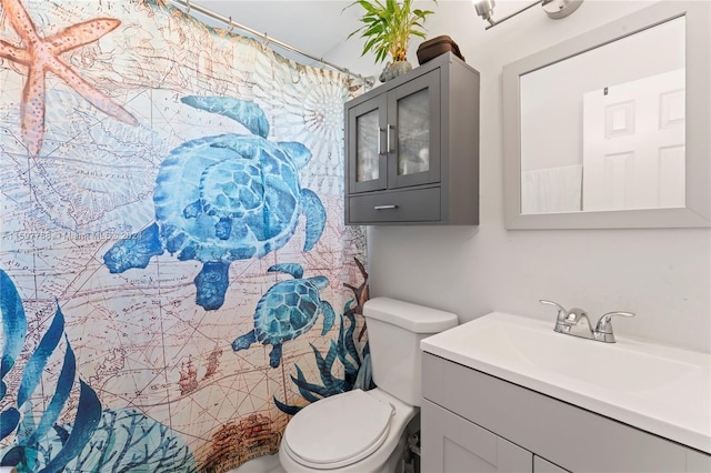 bathroom featuring vanity with extensive cabinet space and toilet