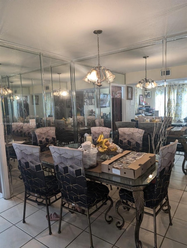 dining space featuring light tile patterned floors and a chandelier