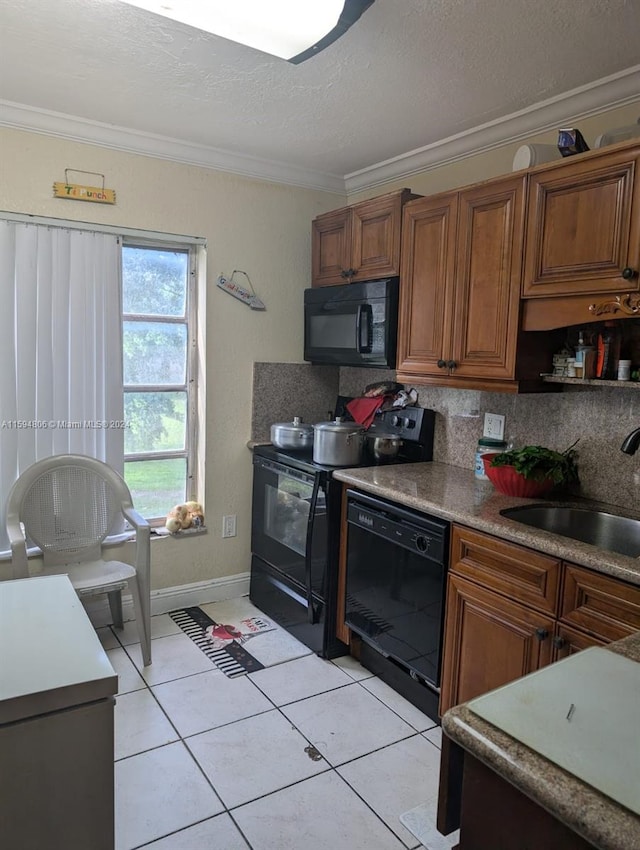 kitchen featuring crown molding, black appliances, backsplash, light tile floors, and sink