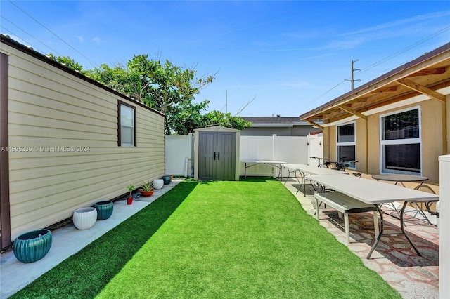 view of yard with a storage shed and a patio