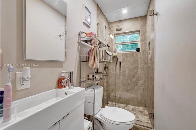 bathroom featuring vanity, toilet, and a shower with shower door