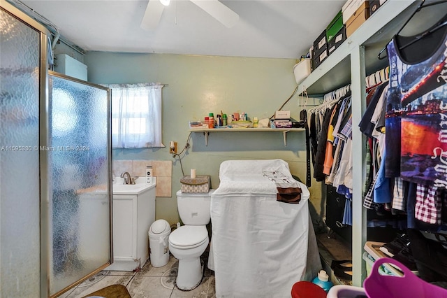 bathroom featuring toilet, vanity, a shower with door, ceiling fan, and tile patterned flooring