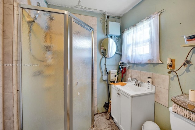 bathroom with tile patterned flooring, toilet, vanity, and walk in shower