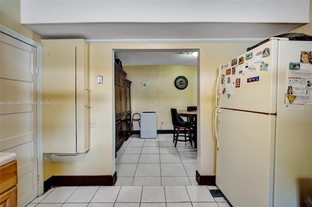 kitchen with white fridge and light tile patterned floors