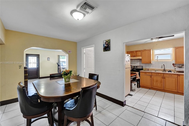 dining space featuring sink, light tile patterned floors, and ceiling fan