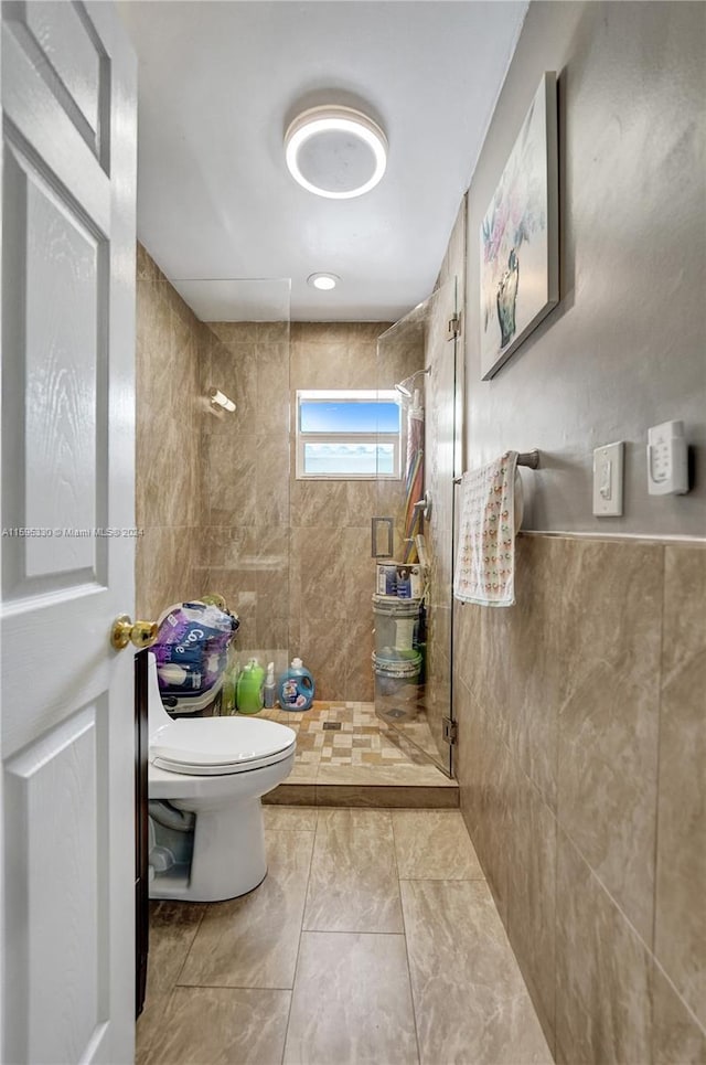 bathroom with tiled shower, tile patterned floors, and toilet