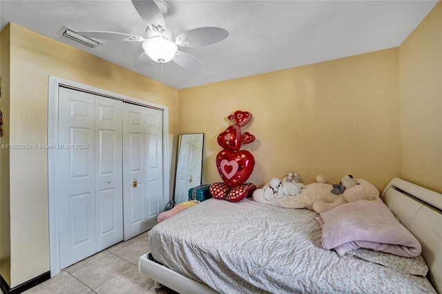 tiled bedroom with ceiling fan and a closet