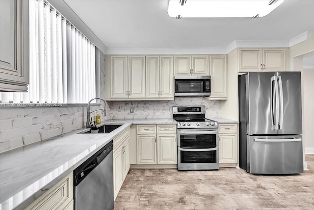 kitchen with cream cabinets, stainless steel appliances, and sink