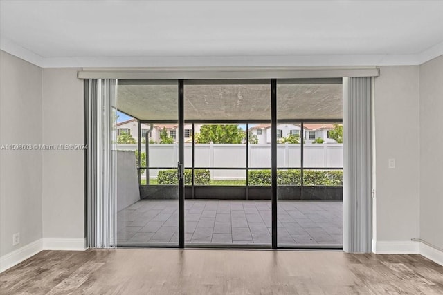 doorway to outside featuring hardwood / wood-style floors and ornamental molding