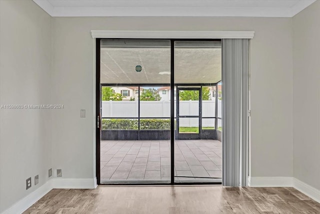 doorway featuring hardwood / wood-style flooring and crown molding