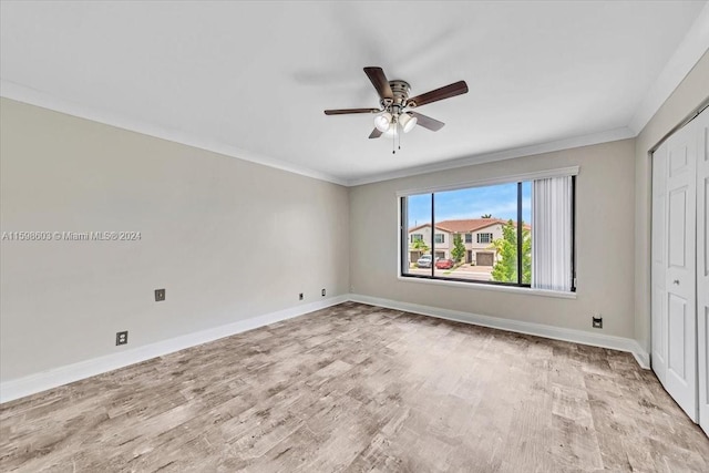 unfurnished bedroom with ceiling fan, a closet, crown molding, and light wood-type flooring