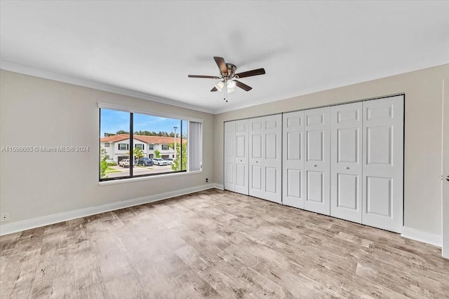 unfurnished bedroom featuring ceiling fan, crown molding, and light hardwood / wood-style floors