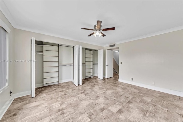 unfurnished bedroom with two closets, ceiling fan, and ornamental molding