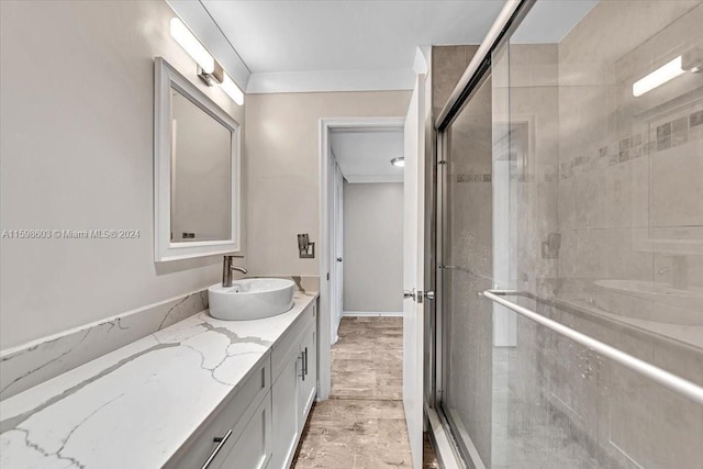 bathroom featuring vanity, ornamental molding, and walk in shower