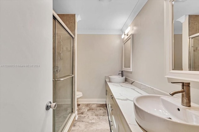 bathroom with an enclosed shower, vanity, toilet, and crown molding