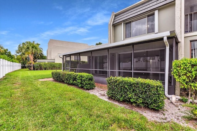 rear view of property with a sunroom and a yard