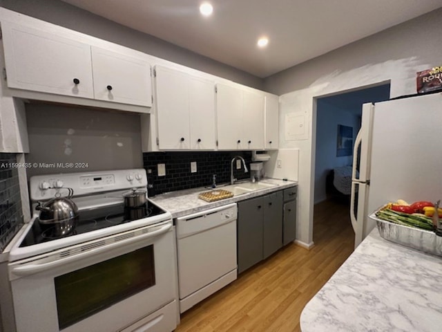 kitchen featuring light hardwood / wood-style floors, white appliances, white cabinets, sink, and tasteful backsplash