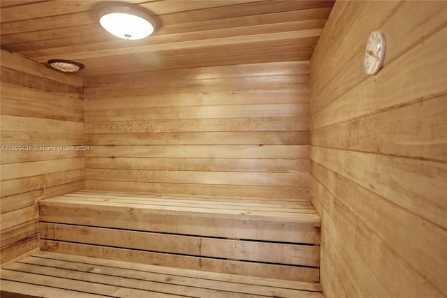 view of sauna / steam room featuring wooden ceiling and wood walls