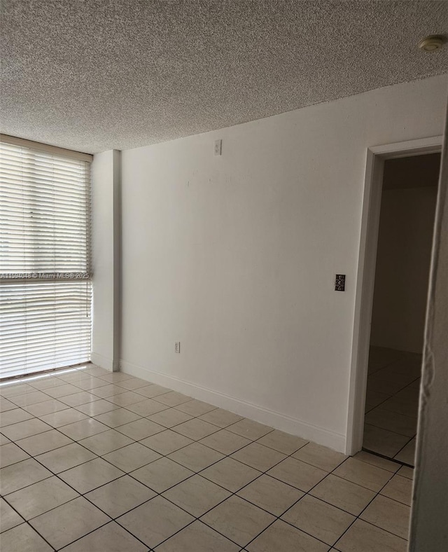 tiled empty room with a textured ceiling