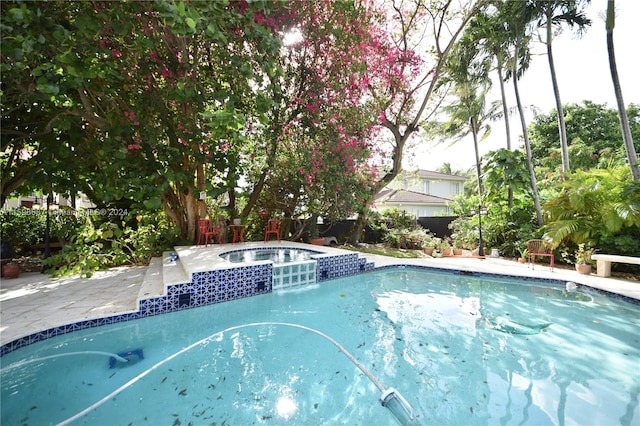 view of swimming pool with an in ground hot tub