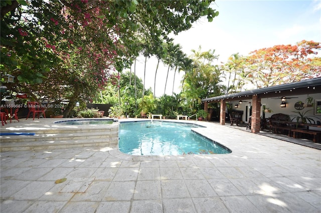 view of pool with ceiling fan, an in ground hot tub, and a patio area