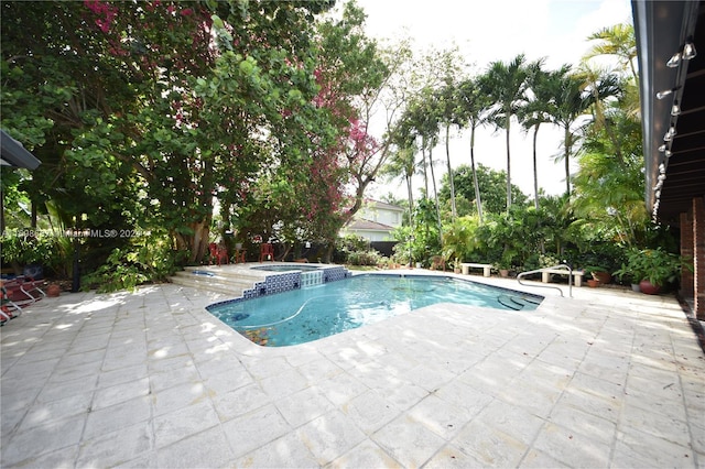 view of pool with a patio area and an in ground hot tub