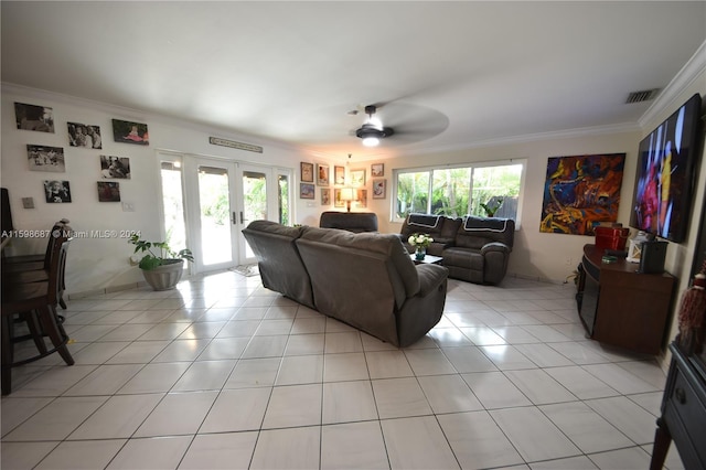 tiled living room featuring ornamental molding, ceiling fan, french doors, and a healthy amount of sunlight