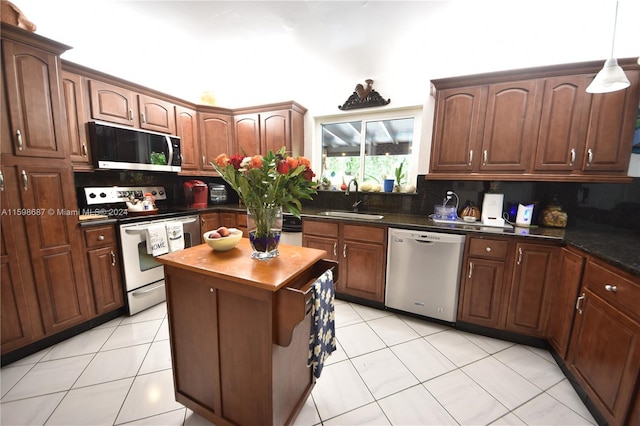 kitchen featuring stainless steel appliances, light tile patterned floors, tasteful backsplash, and sink