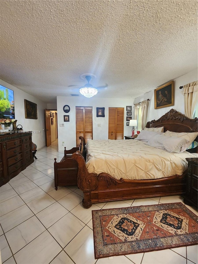 tiled bedroom featuring ceiling fan and a textured ceiling