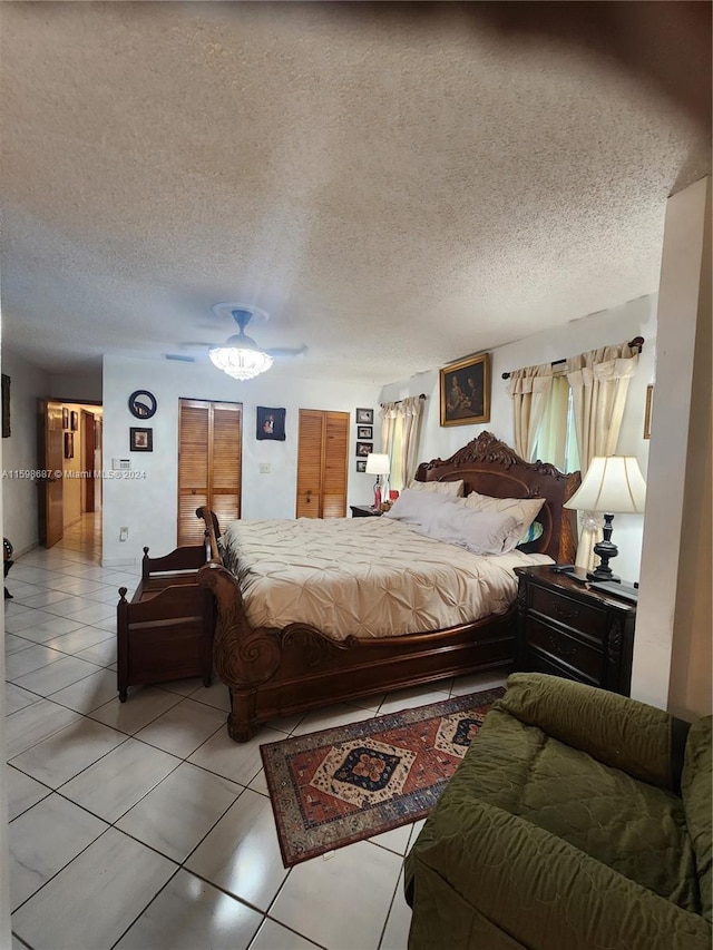 bedroom with light tile patterned flooring, a textured ceiling, and ceiling fan