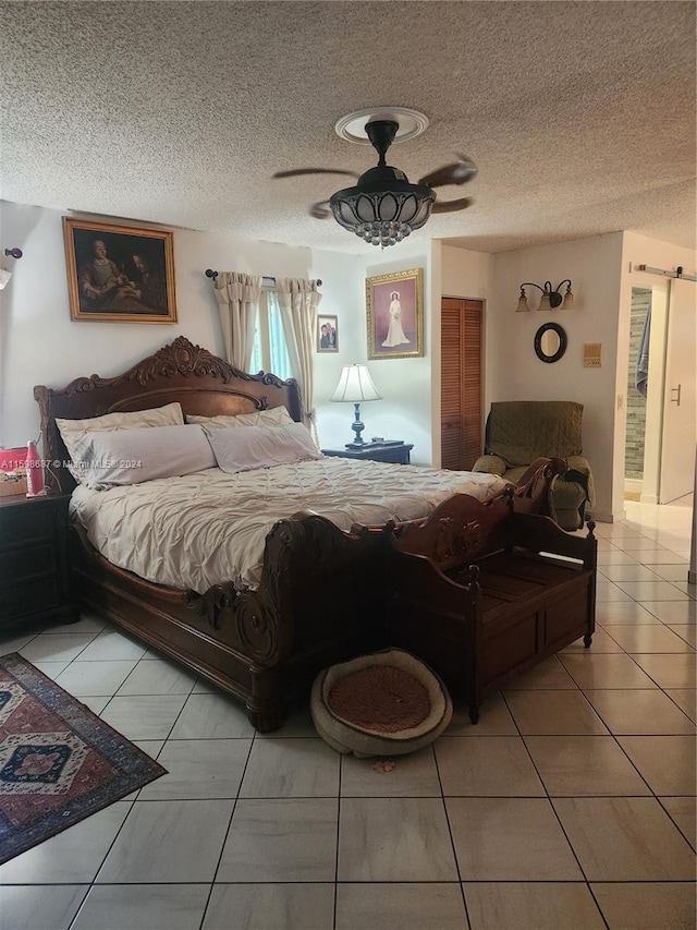 bedroom with ceiling fan, a textured ceiling, and light tile patterned floors