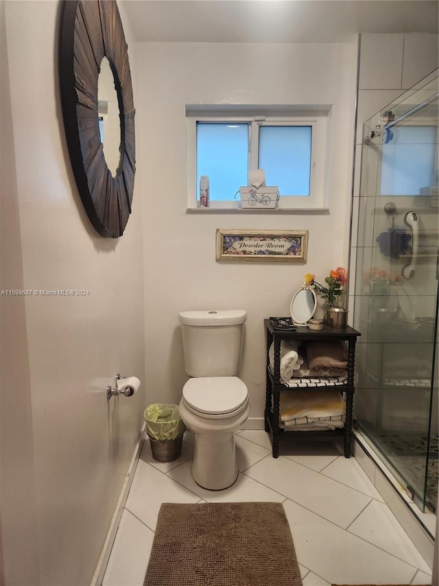 bathroom with a shower with door, tile patterned flooring, and toilet