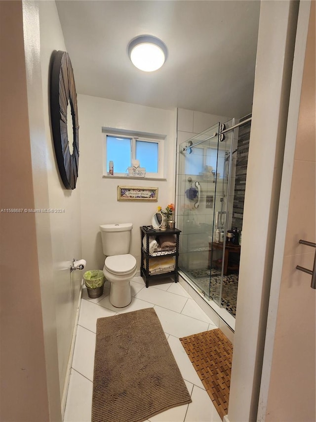 bathroom with tile patterned flooring, a shower with shower door, and toilet