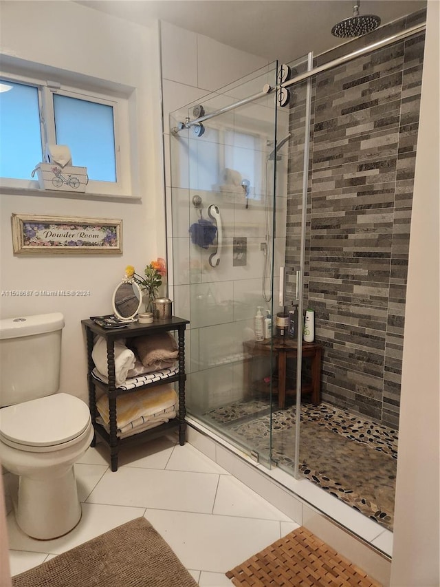 bathroom with a shower with door, tile patterned floors, and toilet