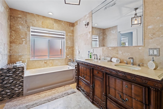 bathroom featuring vanity, tile walls, a washtub, and a healthy amount of sunlight