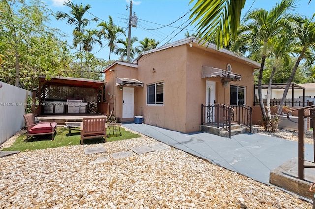 rear view of house with a patio and a hot tub