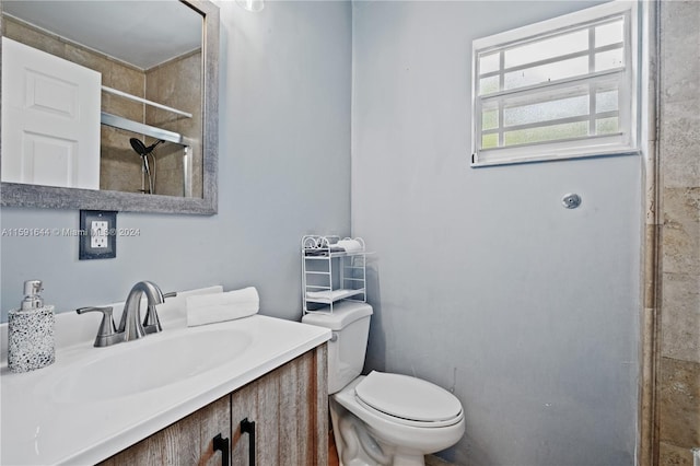 bathroom featuring walk in shower, vanity, and toilet