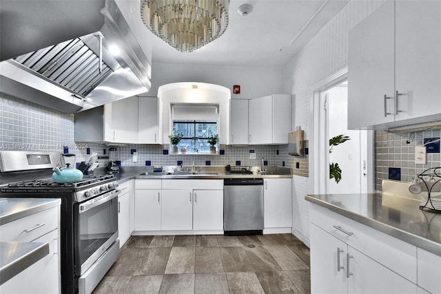 kitchen featuring white cabinetry, range hood, stainless steel appliances, stainless steel counters, and decorative backsplash